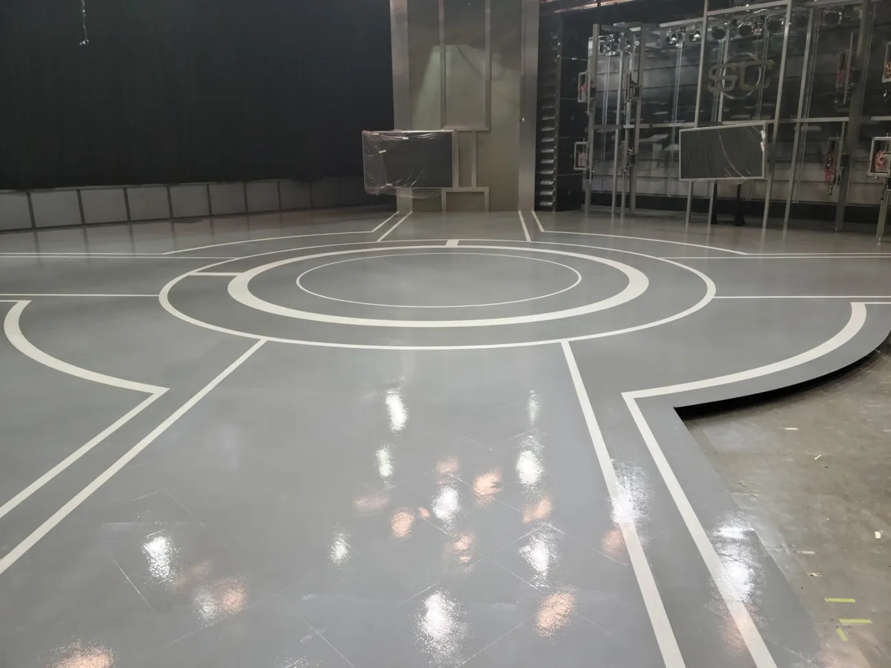 Circular white line work on a glossy gray studio floor