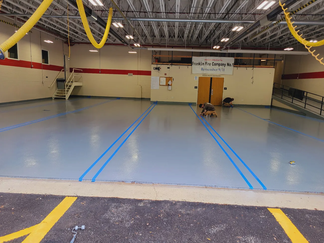 Firehouse bay seen from the driveway, gray epoxy floor with blue bay lines
