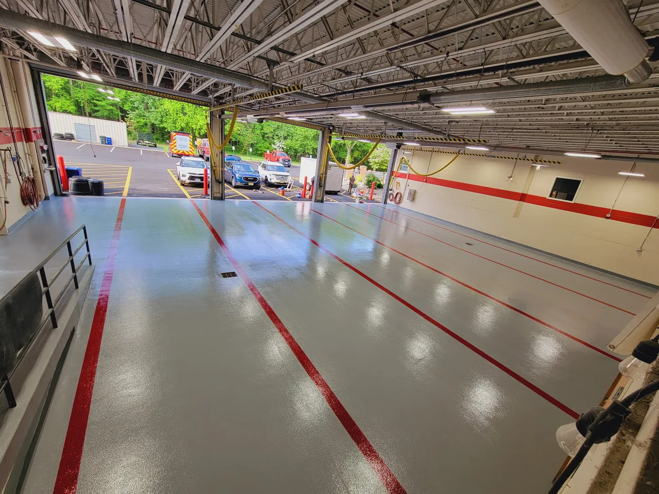 Firehouse bays seen from above, with red lines and light reflecting off the floor