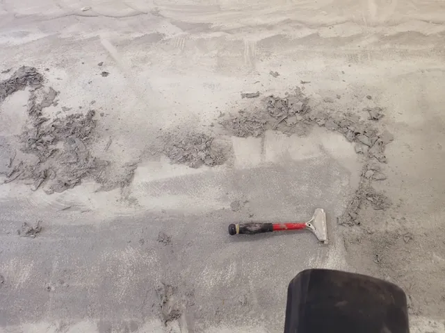 Old floor surface being scraped off the firehouse slab
