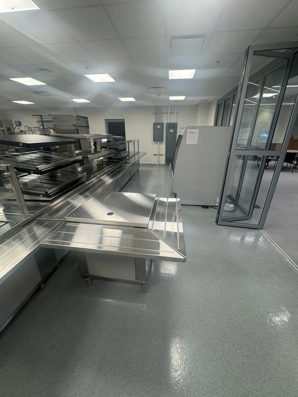 Gray quartz floor at the edge of the serving line next to glass folding doors