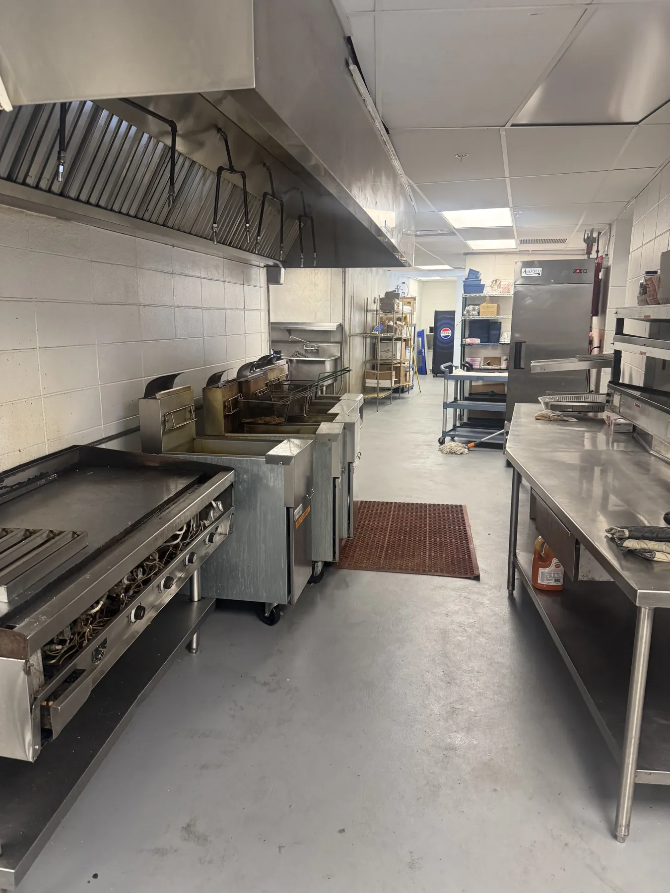 Gray seamless floor along the cooking line of a commercial kitchen