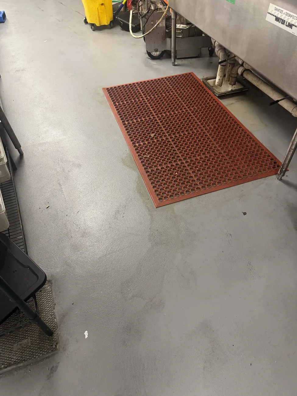 Gray seamless kitchen floor with a red anti-fatigue mat