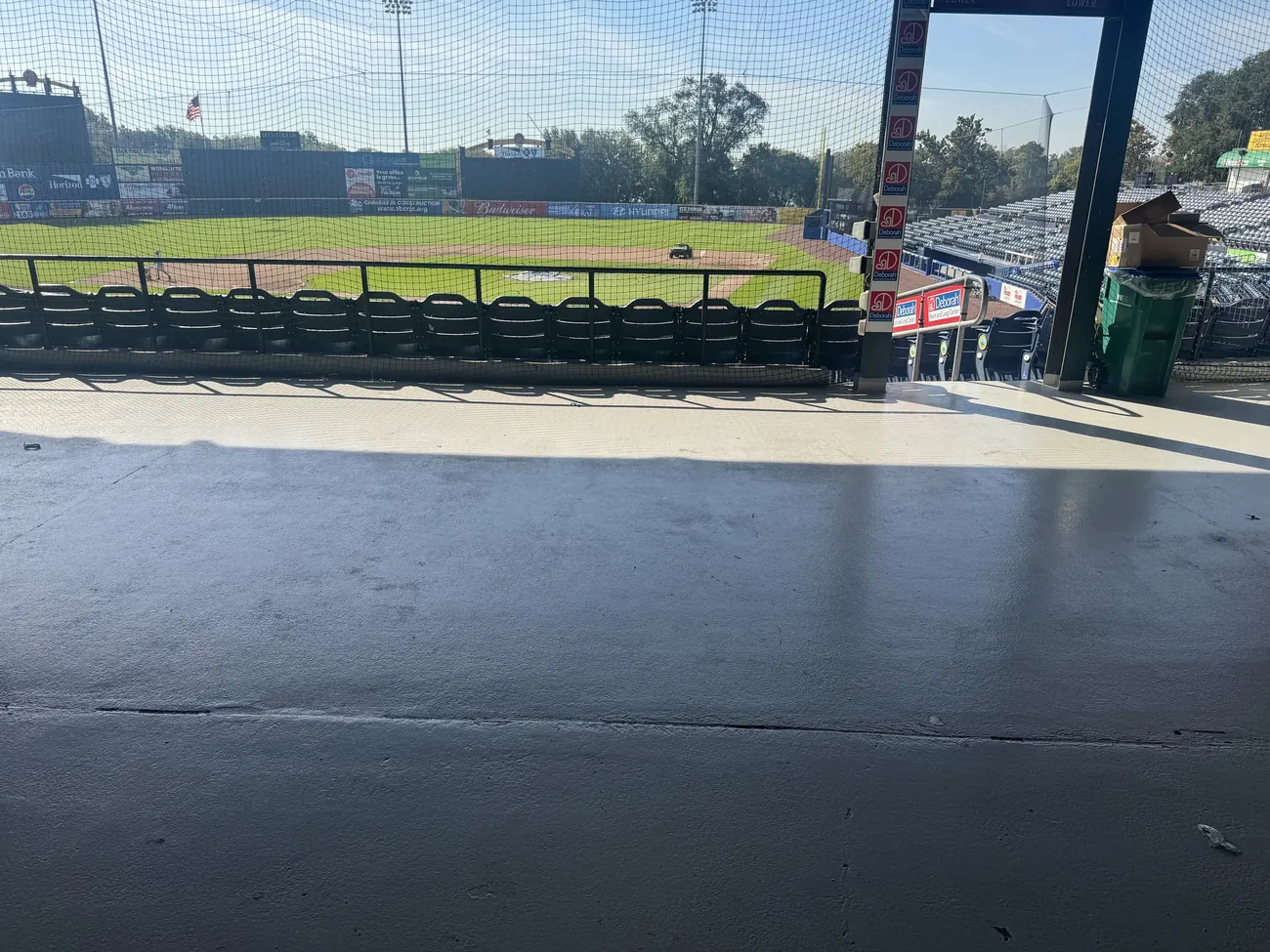 Stadium concourse floor in shade with the baseball field beyond